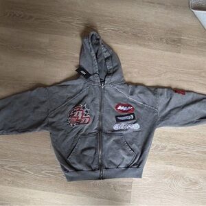 Stylish Gray Zip-Up Hoodie with Graphic Accents